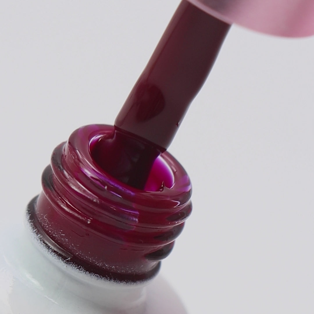 Pincel a ser retirado do boião com cor bordô